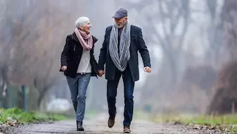 senior couple walking together holding hands outside