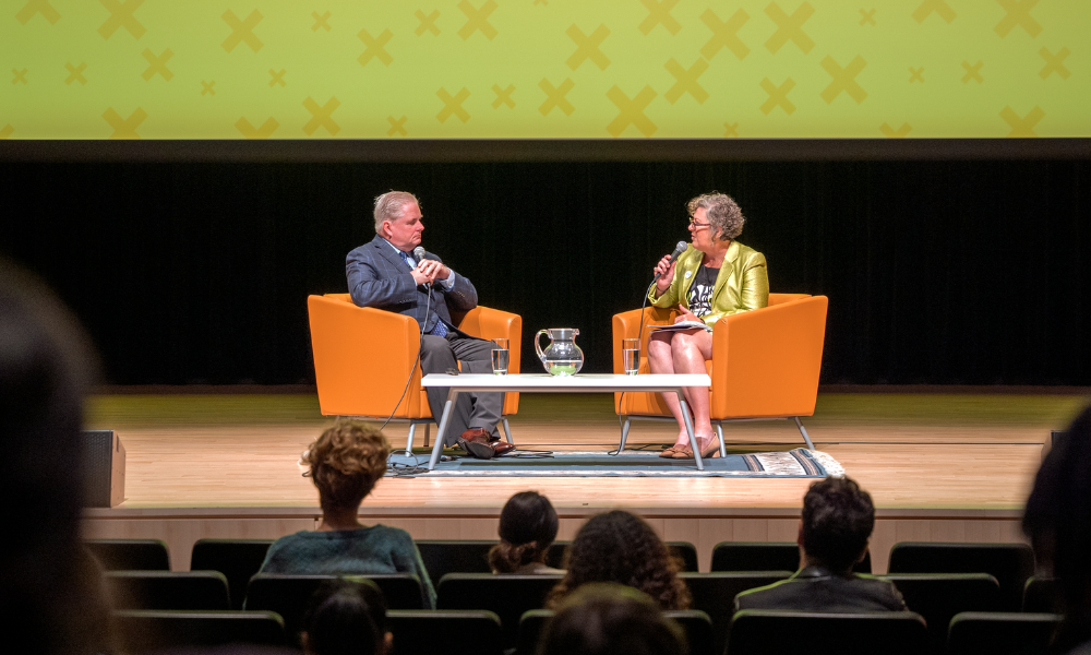 Greg Essensa talking to Karen Bird, on the stage at the McMaster Concert Hall