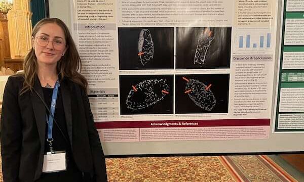 Meg Langlois standing beside a poster of her research