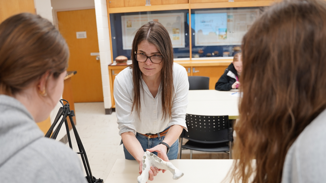 Melissa Dunham showing two students an animal bone inside one of Anthropology's labs.