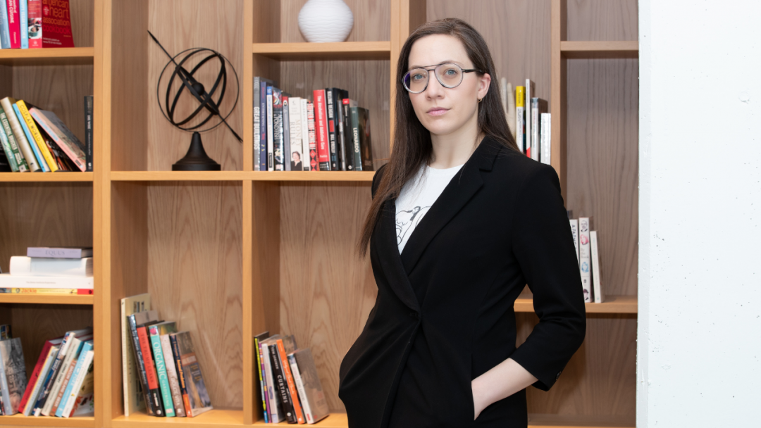 Vass Bednar standing in front a bookshelf