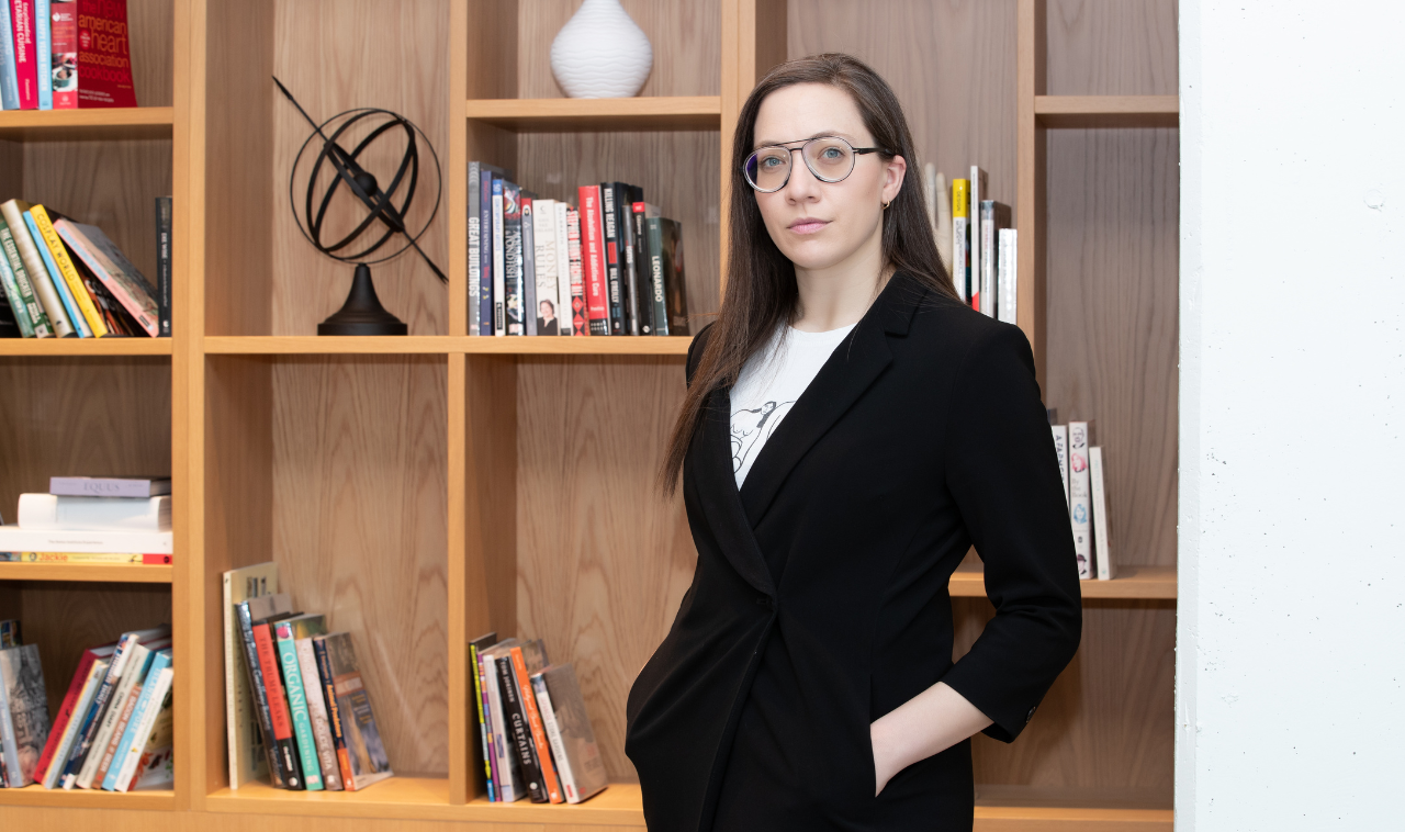 Vass Bednar standing in front a bookshelf